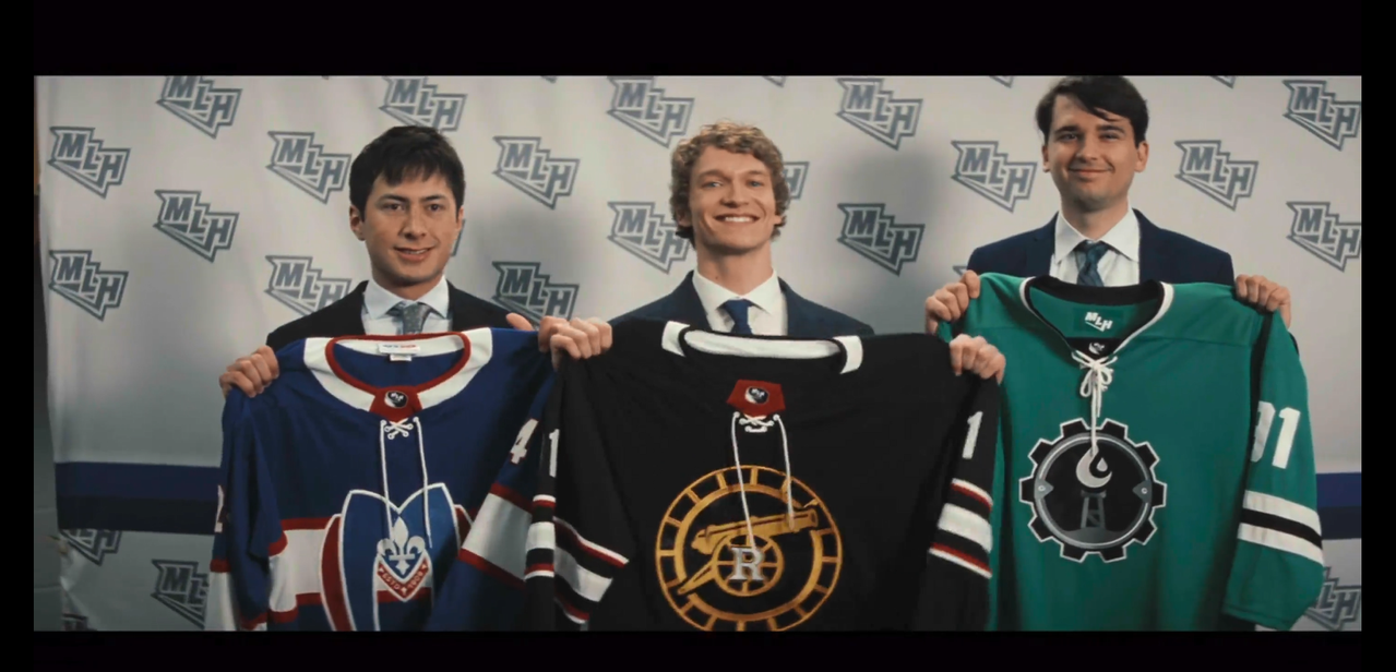 shane, ilya, and a third young man stand in front of an MLH branded wall holding up their jerseys. shane's jersey for the montreal metros is blue, white, and red. it has a dark blue base with a broad white stripe around the middle and neckline, with a thin red stripe around the white stripe. the metros' logo is a big, curvy m in blue with a red partial border and a white fleur-de-lis. ilya's boston raiders jersey is black, white, red, and gold. it has a black base with a broad white strip around the bicep and neckline. the arm stripes have thin white and red stripes above and below the broad stripe. the raiders' logo is a gold canon with a capital r in the wheel and a thin gold tire around it. the third young man's jersey is green, white, and black.