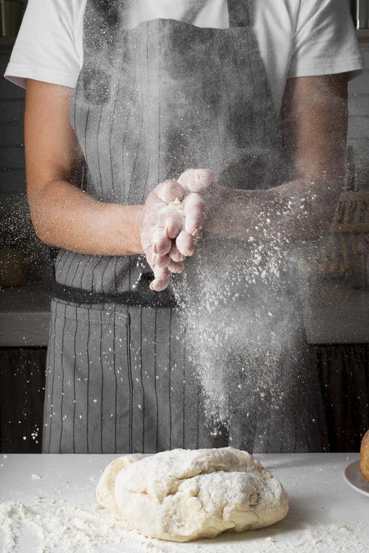Baker clapping hands with flour
