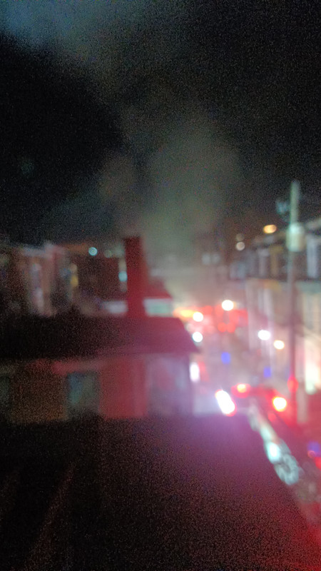 Out-of-focus picture of some fire trucks in an alley, taken from my roof