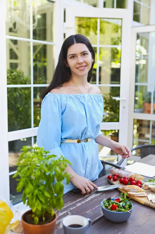 hermosa mujer joven cocinando la cena en casa el jardín 156381525