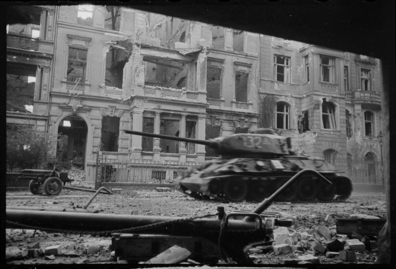 1-й Белорусский фронт. Танк Т-34-85 (№123) движется по разбитым улицам Берлина. На втором плане 76 м