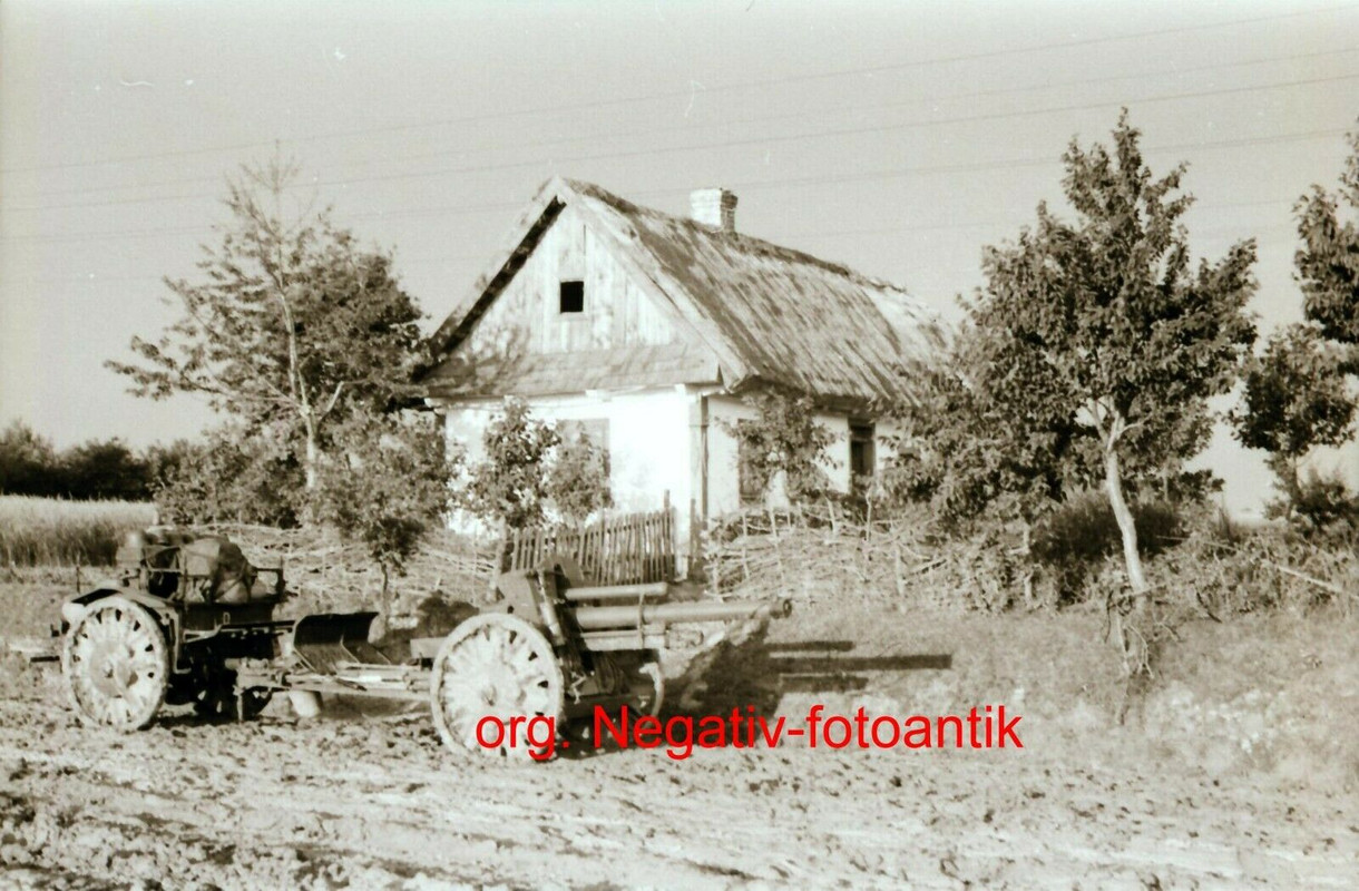 Foto 2 WK Negativ Ostfront Geschütz Haubitze Ausrüstung Wagen vor Bauernhaus