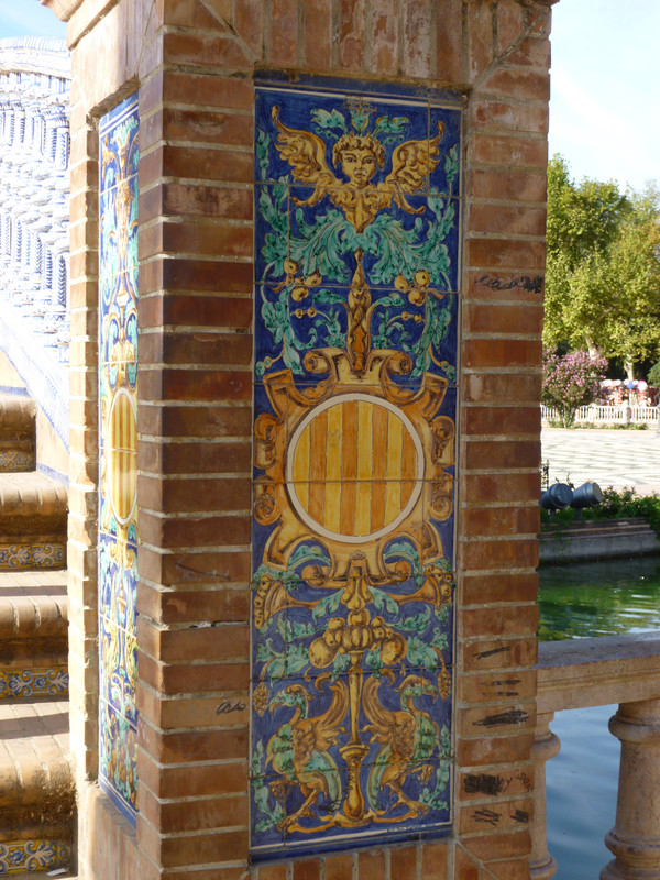 At the ends of the bridges is more decorative tiling.  Each bridge is for one of the 4 kingdoms of Spain.  I'm guessing this is Catalunya from the yellow and red stripes at the centre of the design.