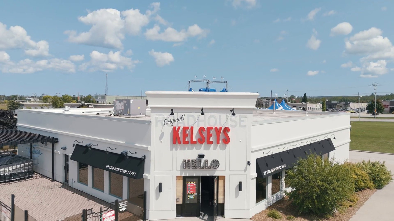 Renovated Kelseys Original Roadhouse storefront with new signage under a blue sky