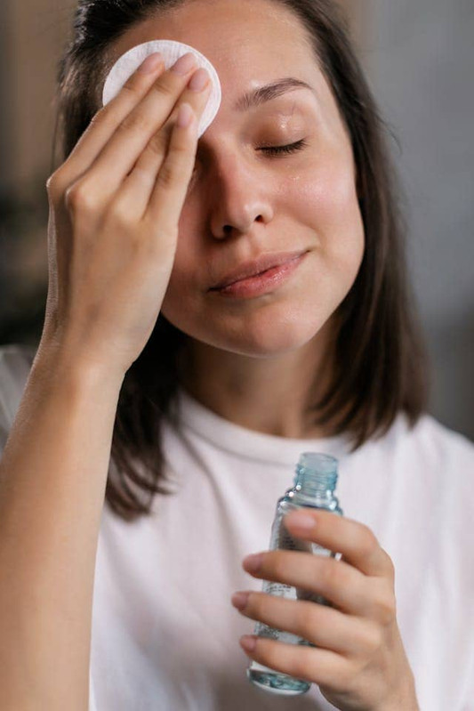 a woman exfoliating her face with chemiscal exfoliants