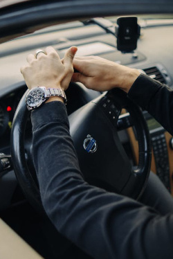 A businessman putting hands on a steering wheel
