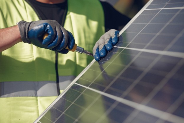 Une personne en train d’installer un panneau solaire sur un toit