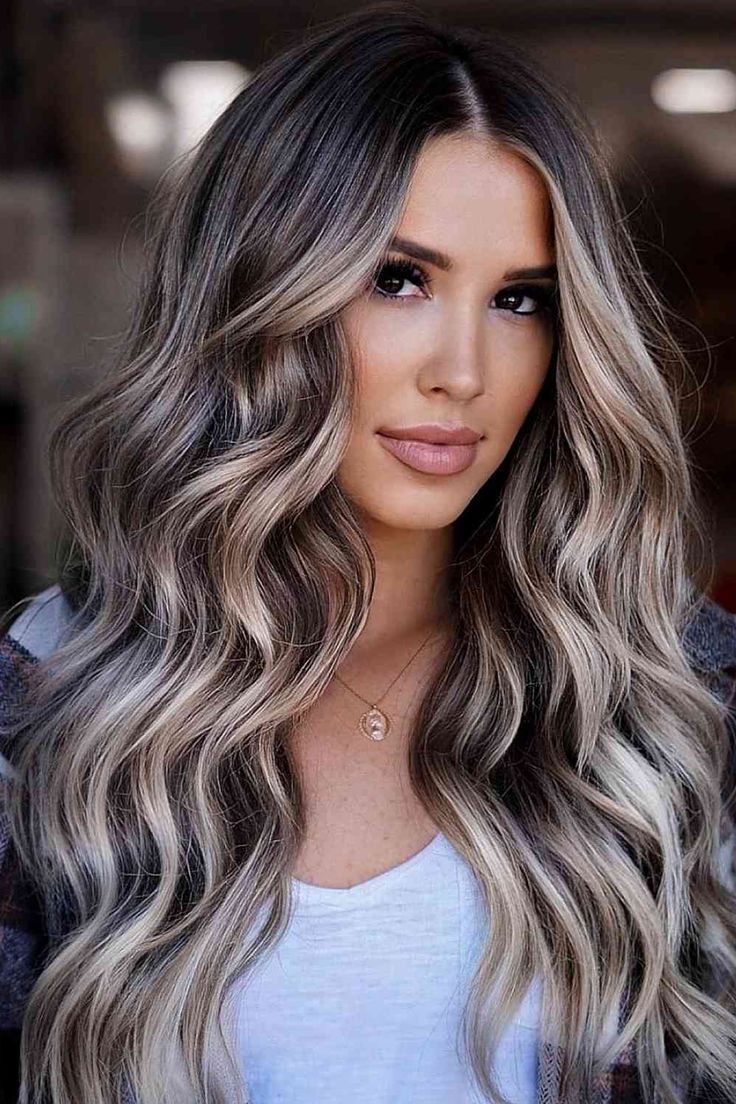 Girl with black eyes and long wavy balayage ash brown hair