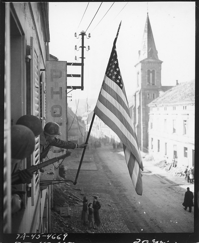 El capitán Thomas H. Garahan, Brooklyn, Nueva York, iza la bandera estadounidense en Bitche, Francia
