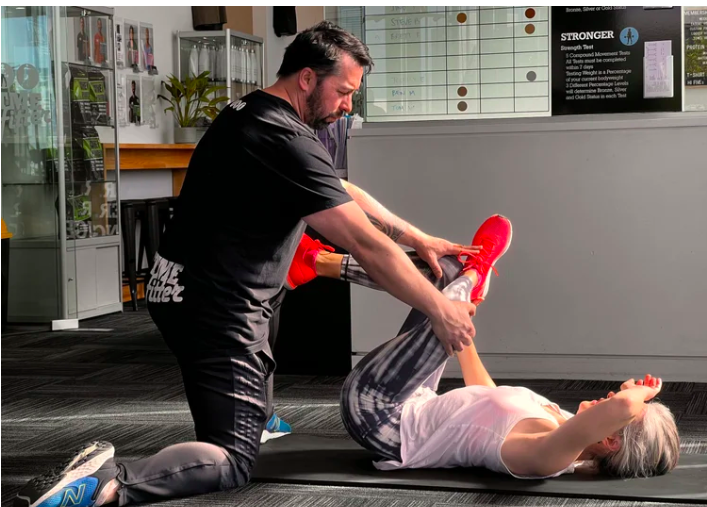 Personal trainer coaching a client through a strength session at a Christchurch gym