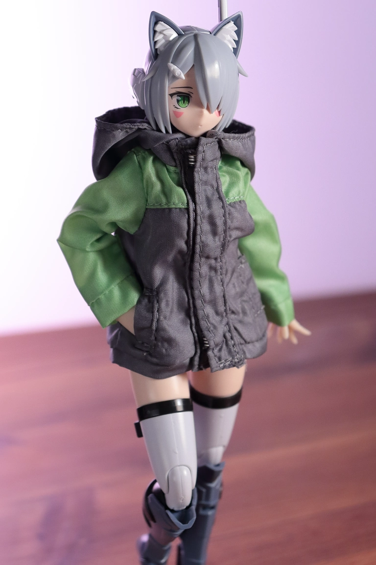 A front view of “Variable Fighter Girls” Kairos girl wearing the parka from a 1/12 Mountain Parka & Short Pants Set in gray and lime