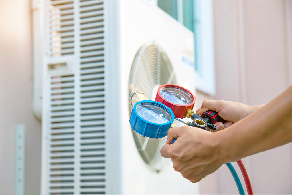 Mechanic using measuring tools for AC repair