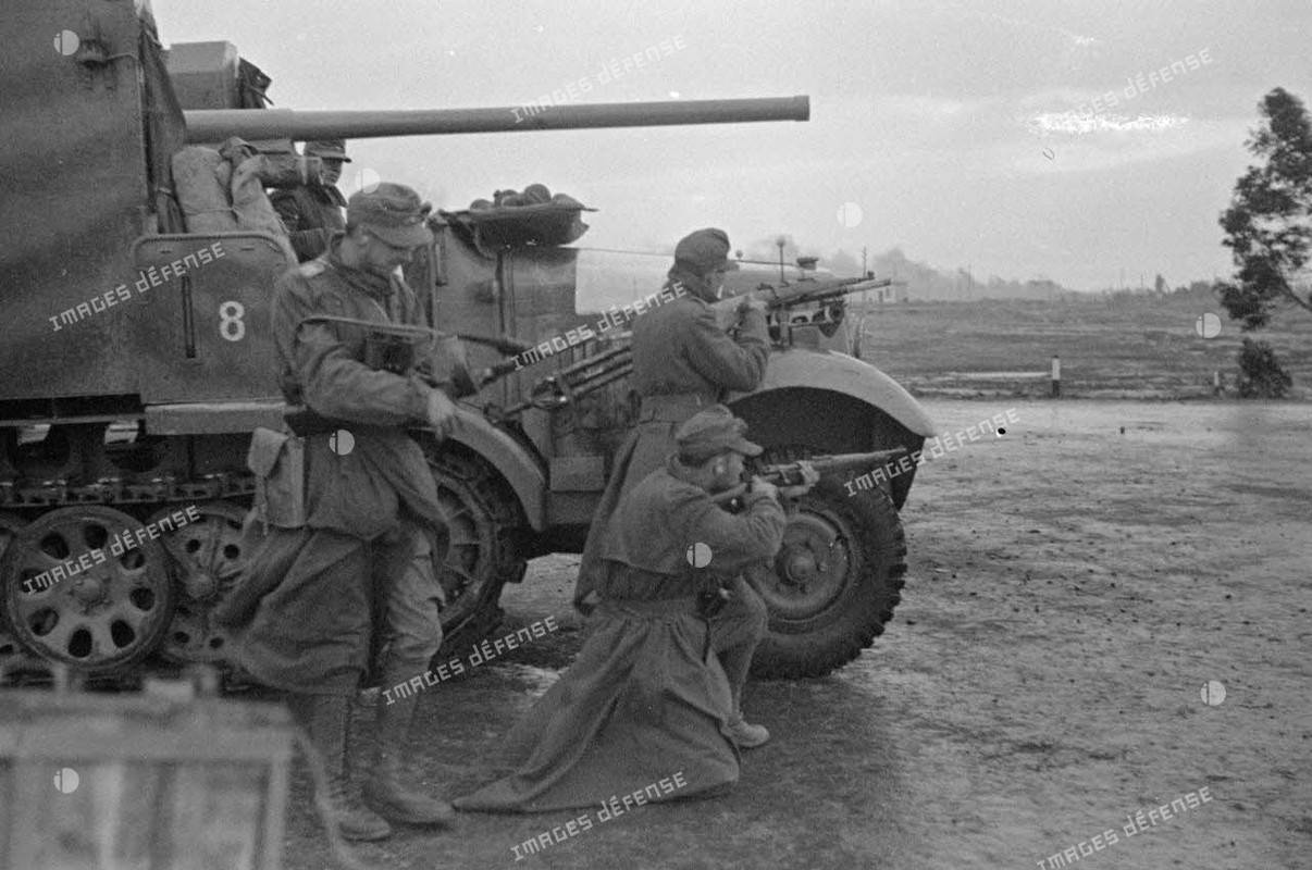 Au premier plan, canon de 3,7 cm PaK puis un semi-chenillé Sd.Kfz-6 transformé en véhicule blindé mu