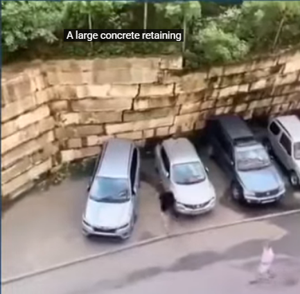 Steinmauer stürzt ein und begräbt Autos