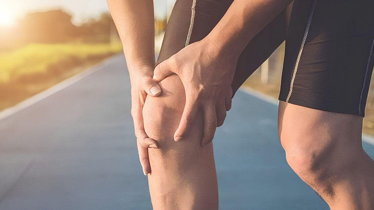 Người chạy bộ ôm đầu gối vì đau, dấu hiệu nghi ngờ chấn thương dây chằng chéo trước