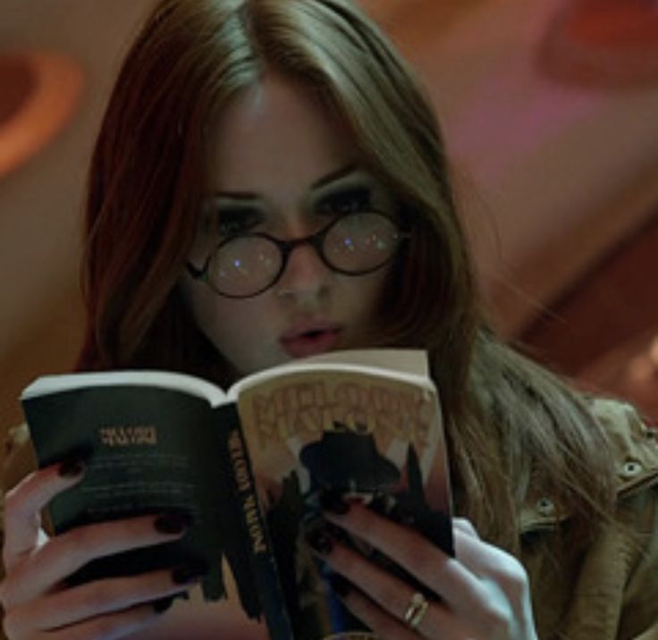 Jovem mulher imersa em leitura relaxando perante uma vista campestre e bela de contemplação.