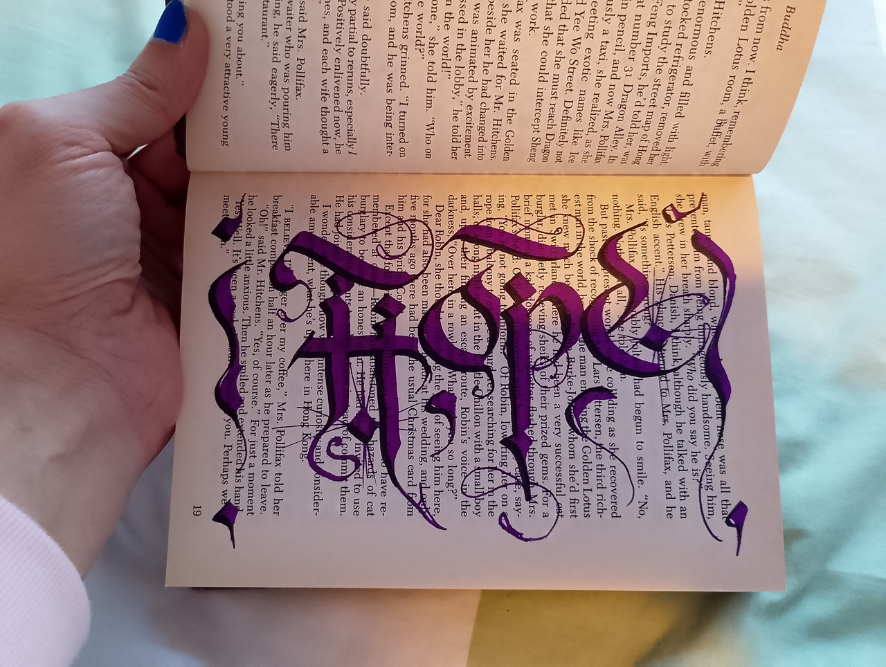 Traditional Calligraphy of the word HOPE in purple color completed inside an old book