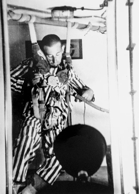 Un prisionero en una cámara de compresión pierde la conciencia durante un experimento para determinar las altitudes a las que las tripulaciones de las aeronaves podrían sobrevivir sin oxígeno. Dachau, Alemania, 1942
