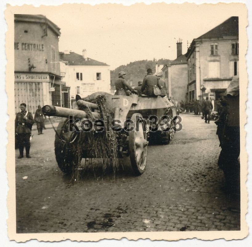 Foto Schutzenpanzer Halbkette mit Artillerie Feldkanone in einer Stadt im Westen