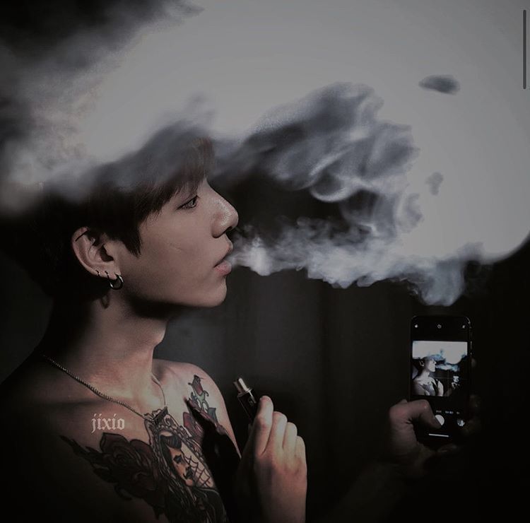 Jungkook smoking a cigarette (or weed)
