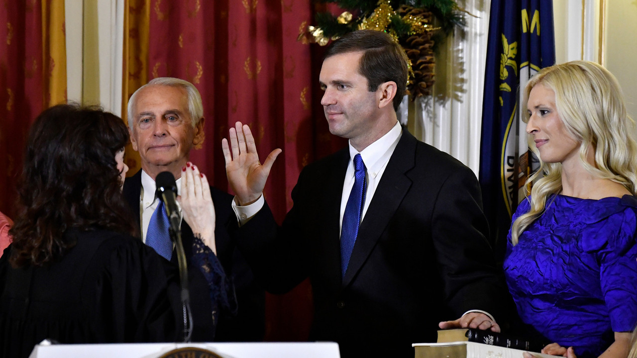 Kentucky Supreme Court Justice Michelle M. Keller, left, gives the oath of office to Andy Beshear to become Kentucky’s governor in Frankfort, on Dec. 10, 2019 while Beshear’s wife, Britainy is holding the Bible.