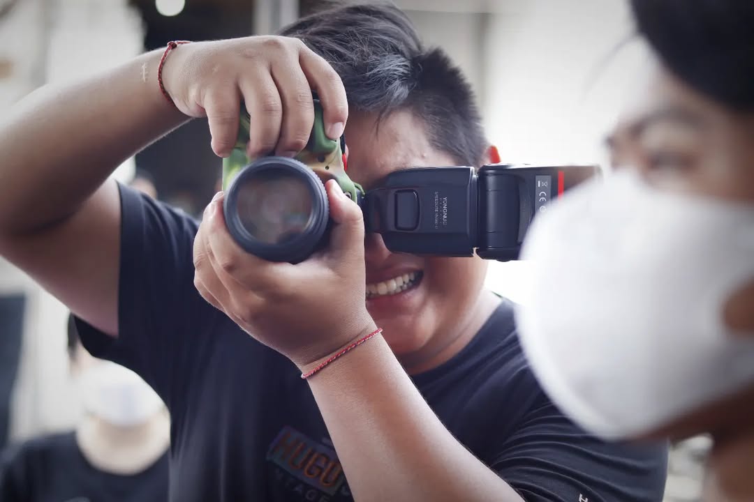 Potret Koko Endut dengan senyum ramah mengenakan kemeja casual dengan latar belakang outdor yang cerah