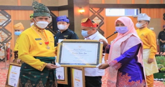 Walikota Pekanbaru Dr Firdaus ST MT menyerahkan Piagam penghargaan ke Camat Tenayan Raya Indah Vidya Astuti sebagai evaluasi kinerja terbaik se-Kecamatan.