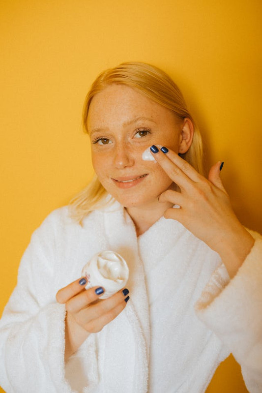 woman applying vitamin C cream for collagen support to the skin