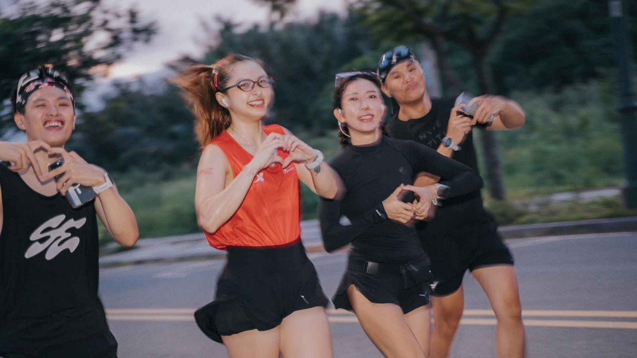 Nhóm bạn chạy bộ cười đùa vui vẻ, làm dấu trái tim trên đường vào chiều tối