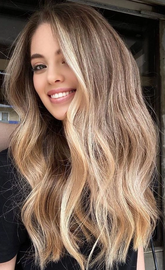 Smiling girl with long wavy ash blonde hair with red roots