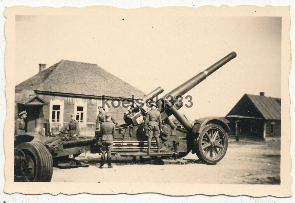 Foto Kanoniere der Wehrmacht an einem 21cm Mörser in einem Dorf im Osten 1941