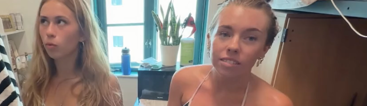 Two hot girls standing in just their bras, showing off their boobs.