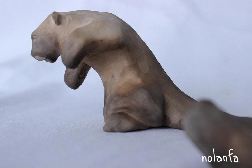 a clay panther with a droplet-like pattern on its side