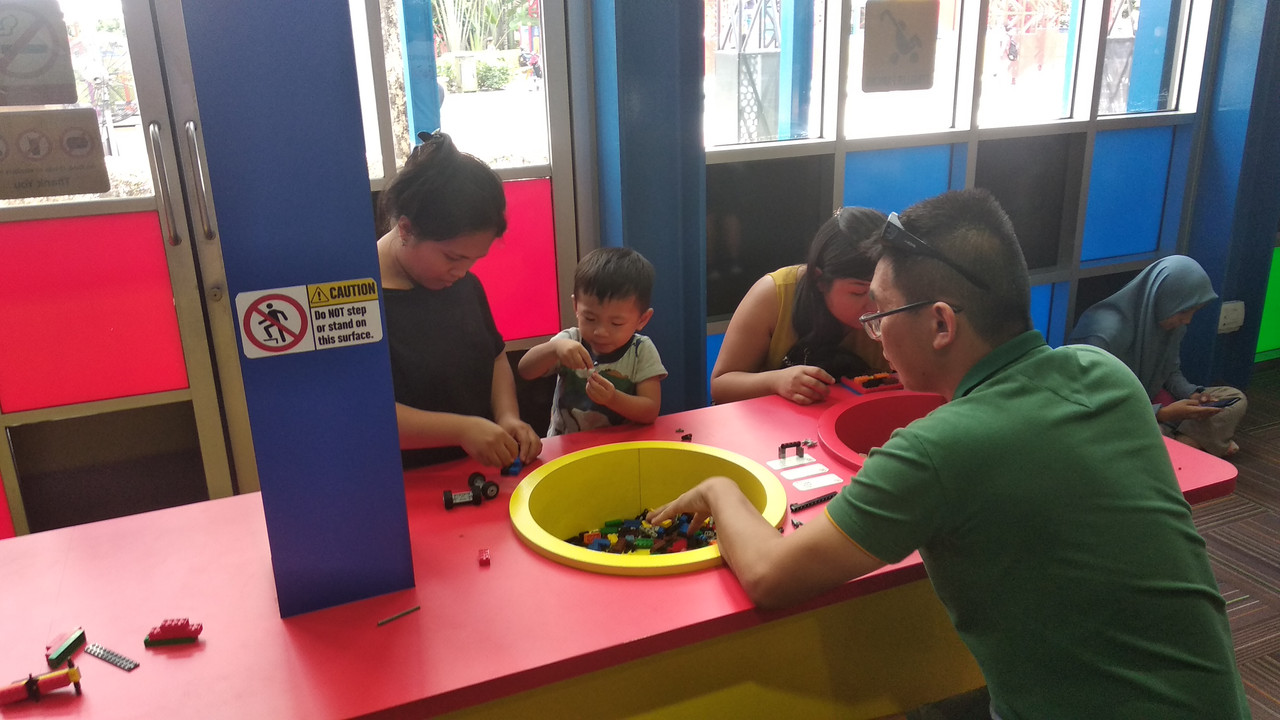 Orang tua dan anaknya sedang membuat sesuatu menggunakan LEGO brick di Build and Test LEGOLAND