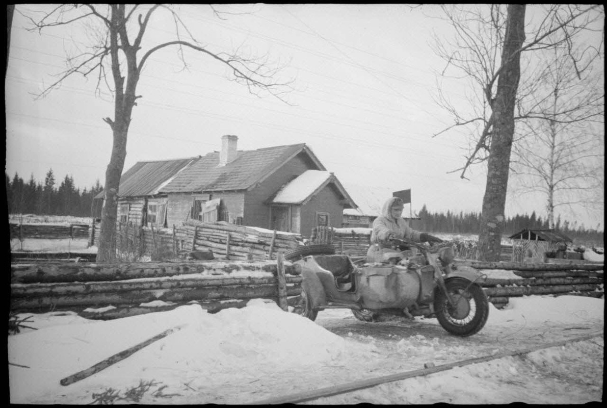 Devant l'isba qui contrôle l'accès à une voie ferrée, la sortie d'une moto BMW R75.1944