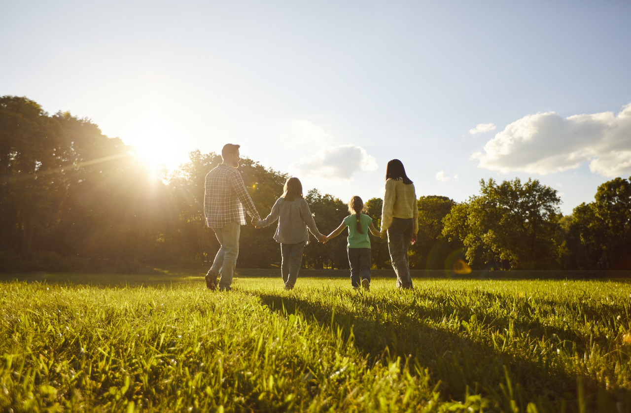 A family walking through a sunlit field.