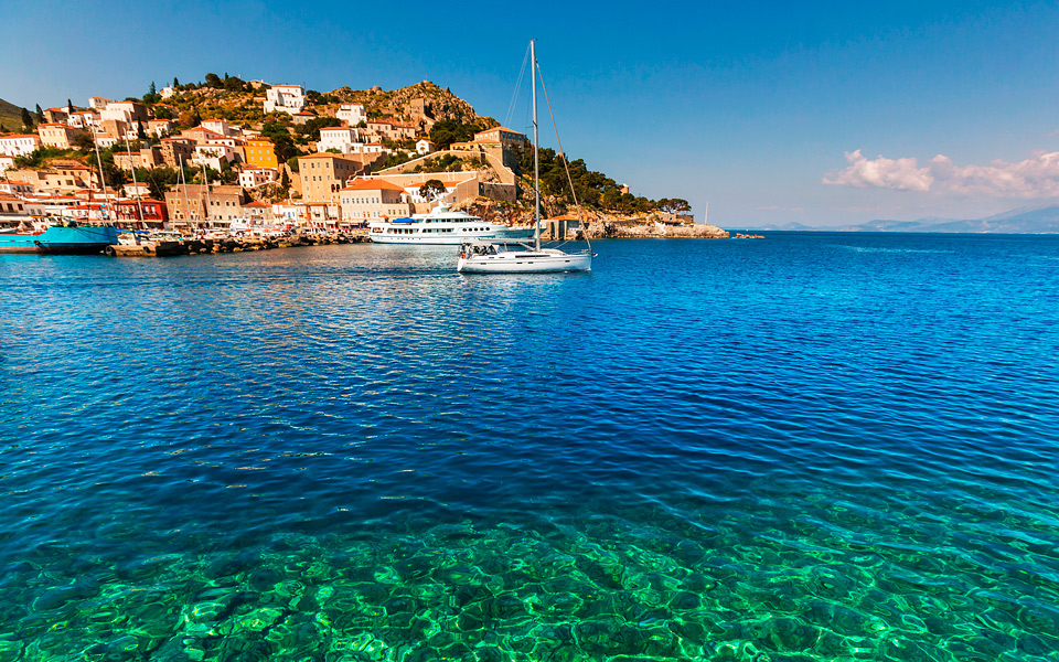 Hydra island whitewashed harbour seen from a yacht day cruise
