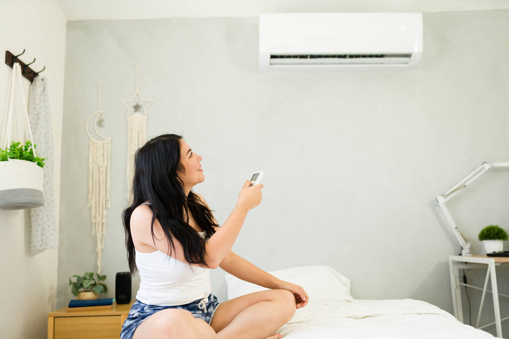 stock photo young woman relaxes her bed remote hand enjoying cool summer