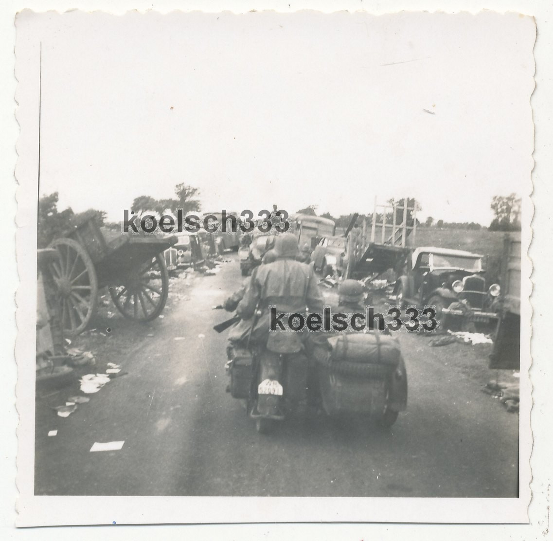 Foto Kradschützen zwischen Fahrzeug Wracks auf Vormarschstraße in Frankreich 1940