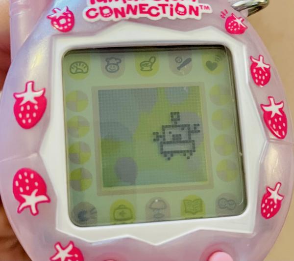 up close photo of a tamagotchi connection device (2024 rerelease) showing ALIBI fully grown into a happy jumping robot