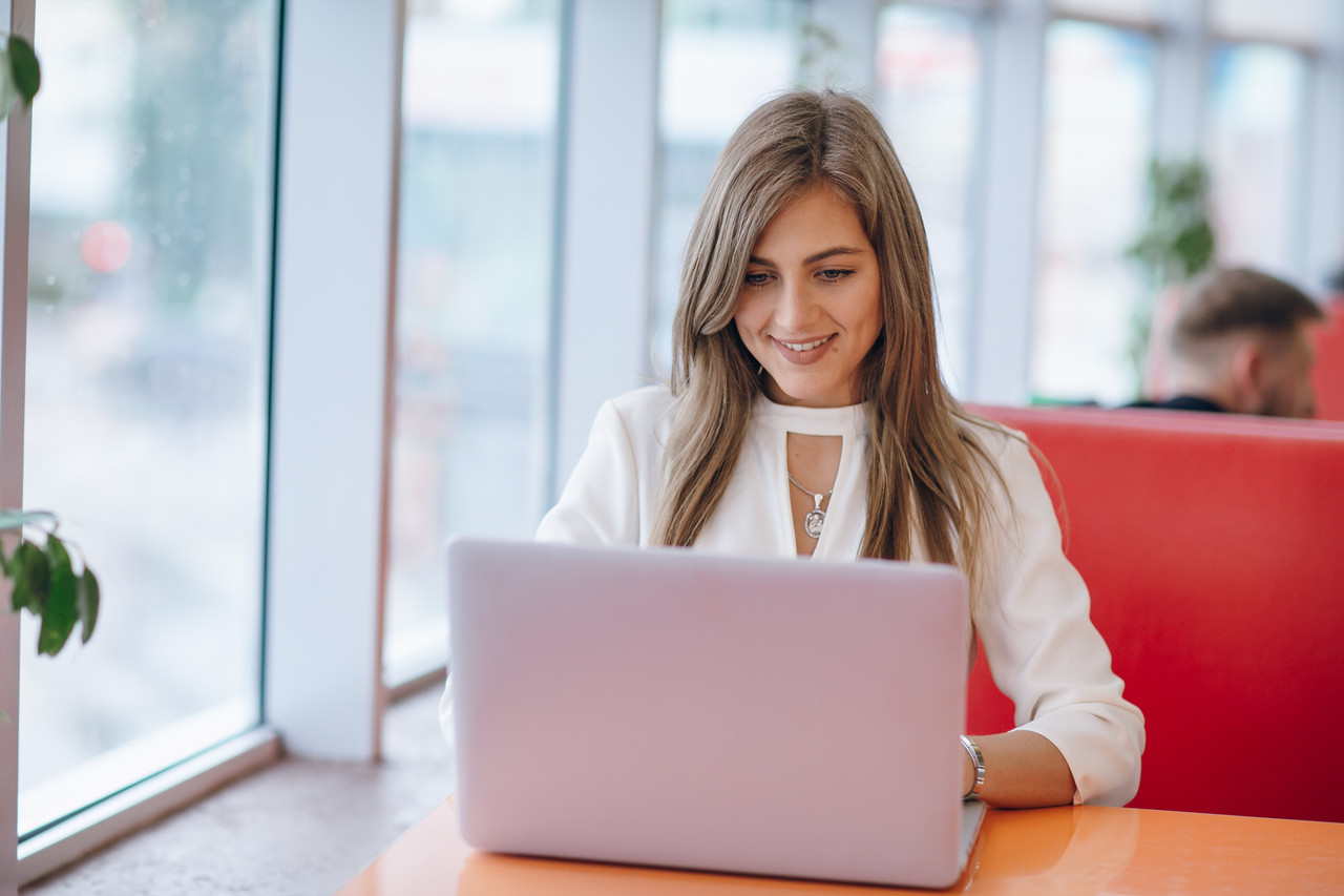 elegant woman with smiling face typing her laptop