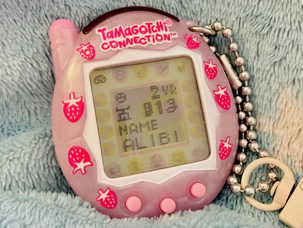 up close photo of a tamagotchi connection device (2024 rerelease) showing ALIBIβs stats page at 2 years old and 81g weight