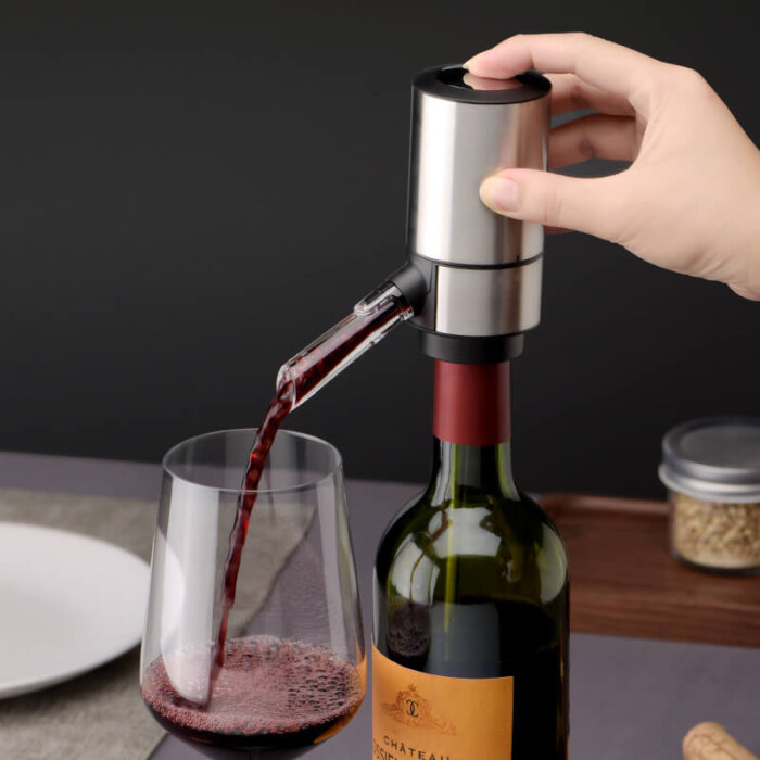 Dispensador eléctrico de vino de color gris, sirviendo vino en una copa.