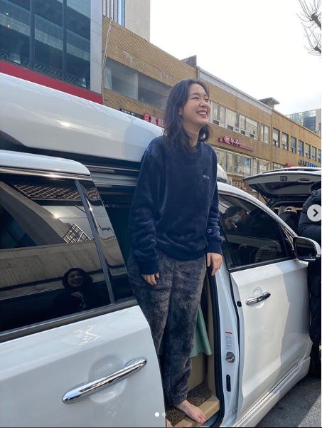 Kim Go Eun berdiri di sebuah mobil