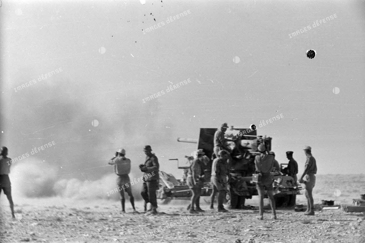Un canon de 8,8 cm FlaK tire en position, attelée à son avant-train.4