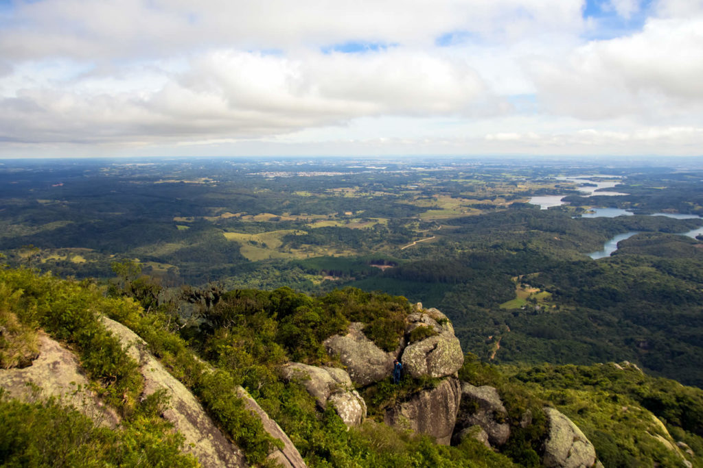 Vista panorâmica do topo do Morro Pão de Loth com Curitiba ao fundo em dia ensolarado