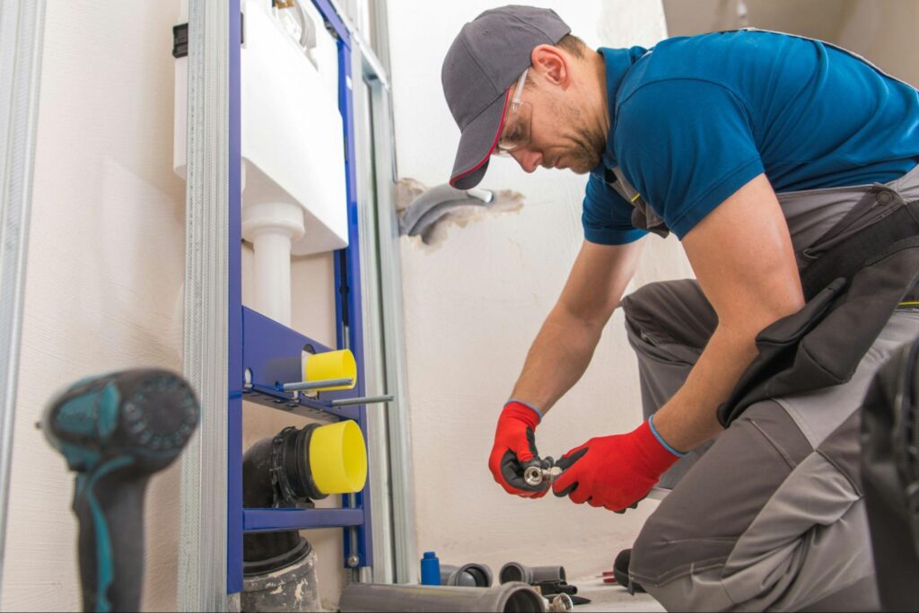 Licensed sump pump installation specialist inspecting pump in Albuquerque basement