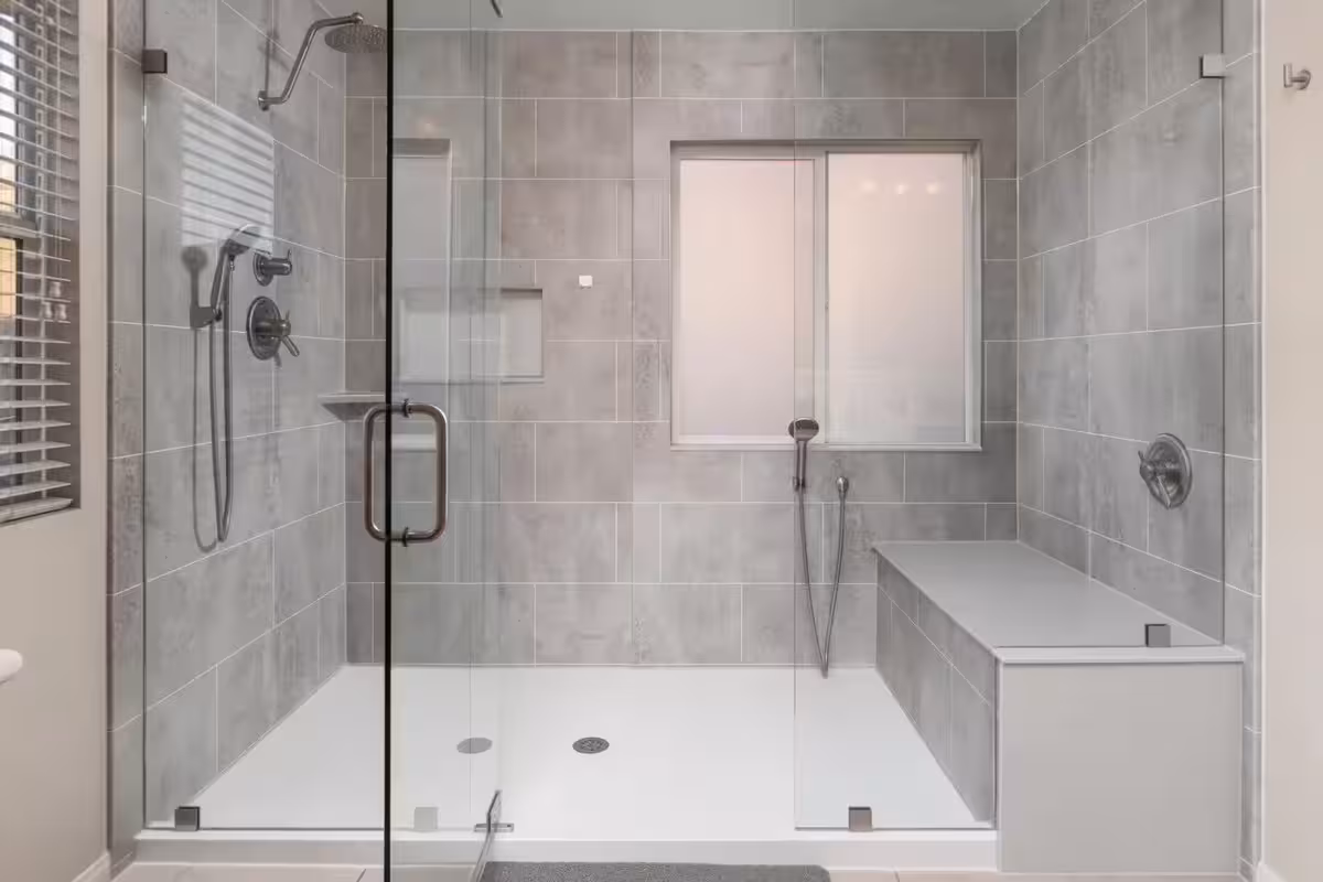 Soaking tub with niche and large-format tile, warm brass fixtures