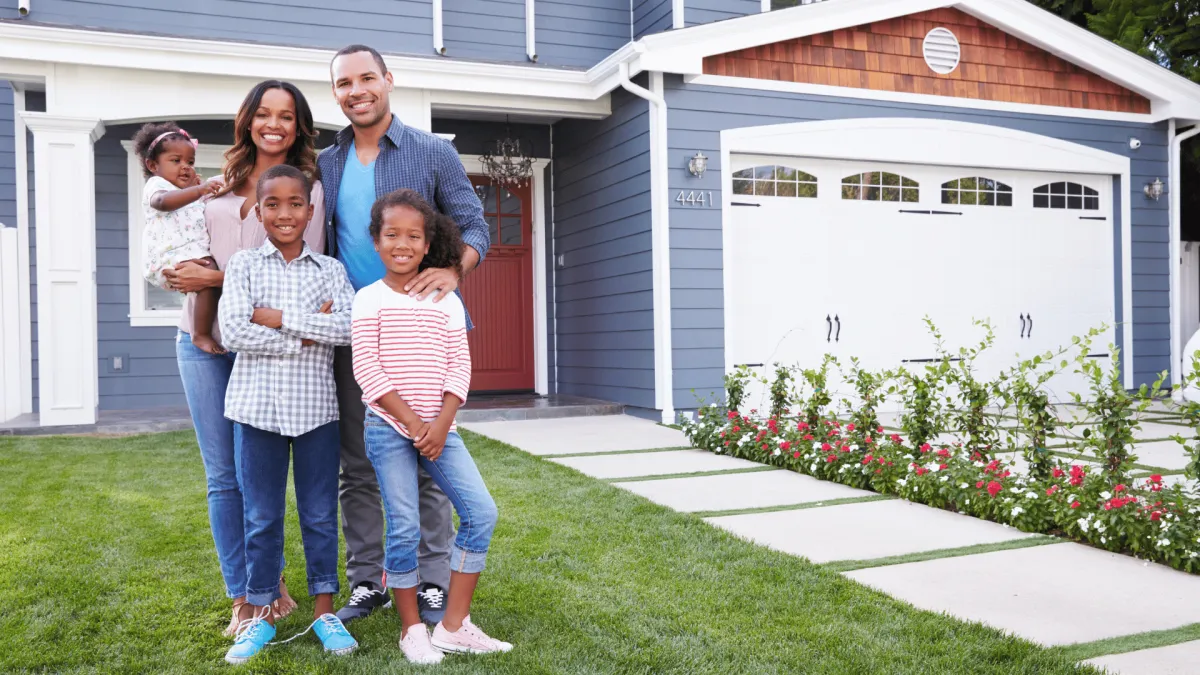 Happy family in front of their home