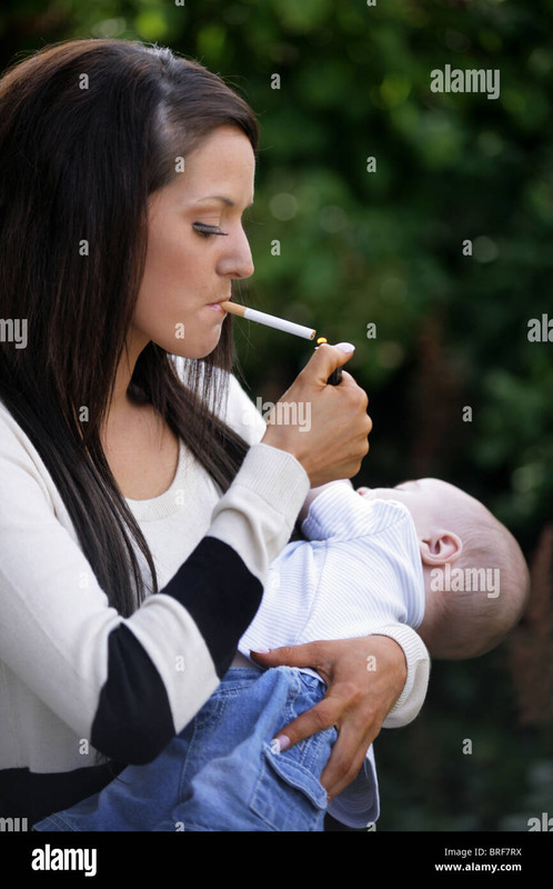 mother-in-her-20s-smoking-a-cigarette-holding-and-her-baby-in-her-BRF7RX
